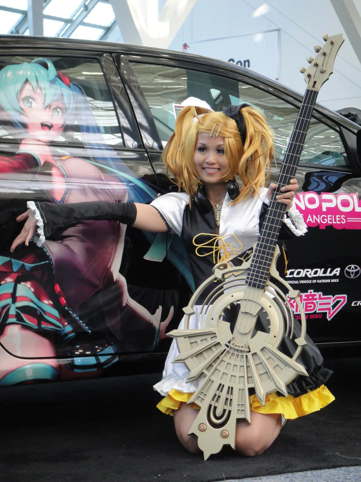 Cosplayer of Kagamine Rin and itasha of Hatsune Miku at Anime Expo 20110701